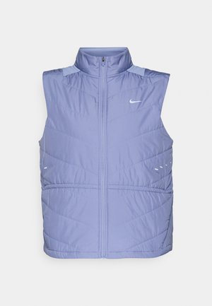 Chaleco sin mangas de plumón en color púrpura claro, con un alto cuello, cierre de cremallera y textura suave. Presenta patrones de acolchado en ángulo y acentos reflectantes.