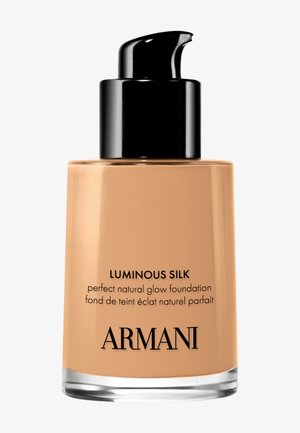 Pumpeflaske med beige Armani Luminous Silk foundation med naturlig glød, svart dispenserlokk og klar glassbase.