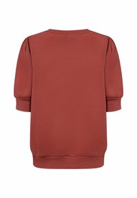 Pullover in rosso ruggine con maniche corte a sbuffo e scollo rotondo. Realizzato in morbido tessuto testurizzato con orlo dritto.