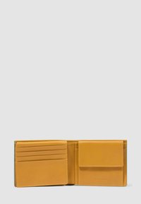 Portafoglio aperto in pelle color cuoio con sei slot per carte a sinistra e tasca per monete con pattina a destra, su sfondo grigio uniforme.