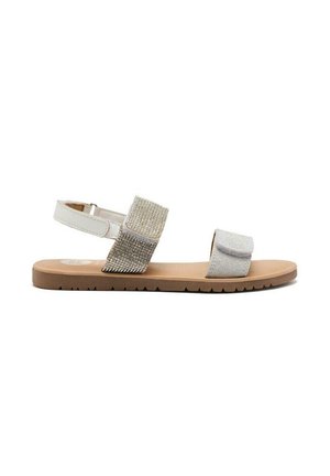 Sandalias plateadas y crema con dos correas anchas, una de las cuales tiene piedras de strass, suela plana marrón y un patrón de agarre texturizado.