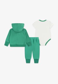 Zielona bluza z kapturem, dopasowane spodnie i biała body. Bluza ma kieszeń z przodu i ribbowe mankiety. Miękki, bawełniany materiał.