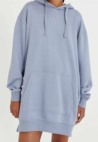 Robe à capuche bleu clair en tissu doux avec poche kangourou, capuche à cordon, coupe oversize et poignets et ourlet côtelés.