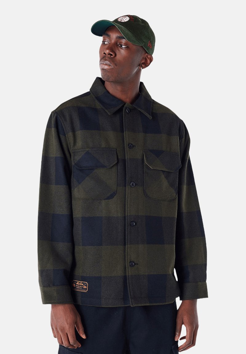 Groene en zwarte geblokte flanellen shirt met knoopsluiting, twee borstzakken en een geweven label aan de linksonderkant. Katoenen materiaal.