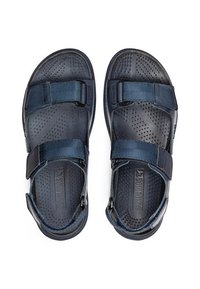 Sandalias azul marino con almohadillas perforadas, correas ajustables y suela texturizada. El material parece ligero y duradero.