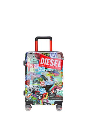 Valigia rigida con manico rosso e adesivi multicolori del marchio Diesel che coprono tutta la superficie, posizionata su quattro ruote.