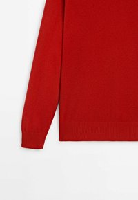 Pull rouge à manches longues avec poignets et ourlet côtelés, présenté sur fond blanc.