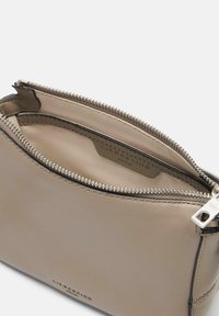 Pochette in pelle beige con zip, dalla texture liscia. L'interno presenta una fodera pulita e un'etichetta del marchio. Cerniera e accessori in argento.