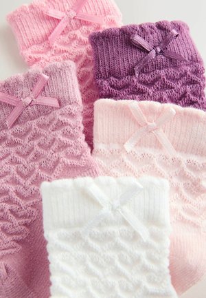 Fem par babystrømper i strik i hvid, pink, lyserød, lilla og mauve, hver med en lille dekorativ sløjfe.
