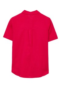 Camicia a maniche corte di un vivace colore rosa, con yoke sul retro e piega. Il tessuto sembra leggero con una sottile trama.