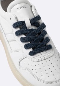 Sneakers in pelle bianca con lacci blu scuro testurizzati, punta traforata e marchio discreto sulla linguetta. Suola in gomma.