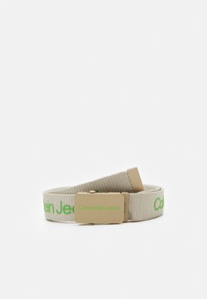 Beige stofbælte med et guldbæltespænde graveret med "Calvin Klein Jeans" i grønt samt matchende grøn logo tekst på bæltet.