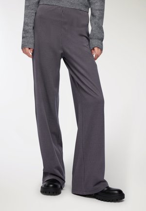 Pantaloni a gamba larga in un modello a righe grigio scuro. Realizzati in un tessuto morbido, presentano una vestibilità rilassata e una texture liscia e fluida.