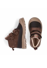 Bruine enkelboots met twee klittenbandsluitingen, een rubberen neuskap en een robuuste zool. Het bovenwerk heeft een combinatie van gladde en textuurmaterialen.