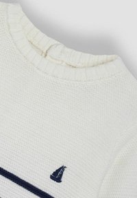 Weißer gestrickter Pullover mit ribbelndem Ausschnitt, versehen mit einem marineblauen Streifen und einem kleinen Segelboot-Logo auf der linken Seite. Texturierte Stoff.