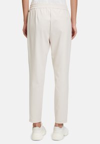 Lichtbeige joggers met een elastische tailleband en zijzak, met een tapering bij het been en zachte, gestructureerde stof.