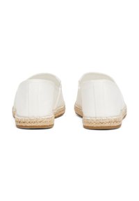 Baltos drobės espadrilės su pintu jutos padu, pasižyminčios paprastu dizainu, švelnia tekstūra ir elastingais šoniniais akcentais, užtikrinančiais patogų prigludimą.
