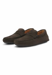 Mocasines de ante marrón con punteras redondeadas, costuras decorativas y diseño de fácil acceso. Textura suave y interior acolchado para mayor comodidad.