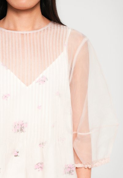 Könnyű, áttetsző blúz V-nyakkal, függőleges csíkokkal és finom rózsaszín virágmintákkal. Puffos ujjak rugalmas mandzsettával.