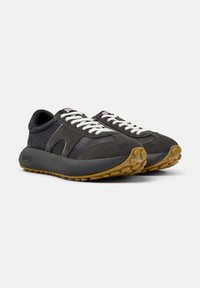 Black athletic shoes with a mix of leather and suede, featuring white laces, a cushioned sole, and a textured gum rubber outsole.