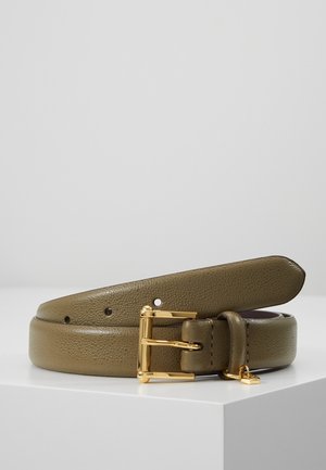 Ceinture en cuir texturé vert olive avec boucle rectangulaire dorée et petit pendentif doré, enroulée sur une surface blanche sur fond gris.