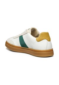 Sneaker bianca con una striscia in suede verde e un accentu in suede giallo sul tallone. Suola in gomma, design con lace-up, tomaia in pelle liscia e una palette di colori neutri.