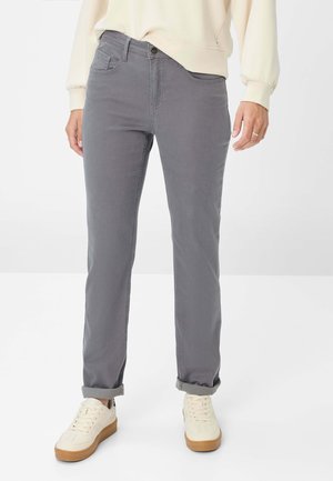 Pantaloni di cotone grigi con vestibilità dritta, dotati di tasche frontali, chiusura con bottone e orli arrotolati, abbinati a sneakers bianche.