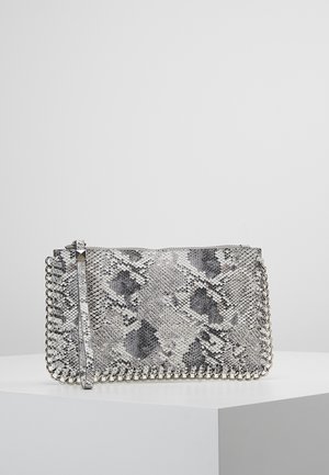 Bolso de mano rectangular con patrón de piel de serpiente gris y negro, con un borde de cadena plateada a lo largo de los bordes y una correa de muñeca sobre una superficie blanca.