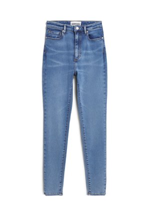 Hellblaue Skinny Jeans aus Denim mit hoher Taille, fünf Taschen und kupferfarbenen Beschlägen. Glatte Textur mit leichter Ausbleichung.