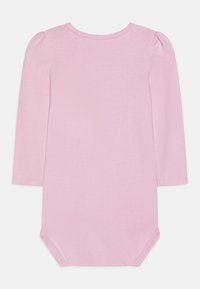 Bodysuit s dugim rukavima od mekog, svijetloružičastog materijala. Ima okrugli izrez i nabirane rukave. Kopčanje na dnu pomoću dugmadi.