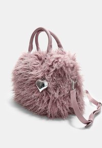 Faux fur håndtaske i blød pink med en rund form, der har korte håndtag og en aftagelig skulderrem. Metalhjertecharms inkluderet.