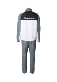 Joggedress med svart og hvit overdel, grå ermer og matchende grå bukser; lett materiale; elastiske mansjetter og midje.