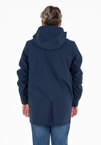 Giacca impermeabile blu navy con cappuccio, caratterizzata da una texture liscia, maniche lunghe e un taglio a lunghezza intermedia. Design minimalista senza hardware visibile.