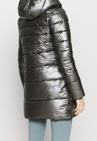 Tmavě šedý péřový kabát s lesklou, hladkou texturou. Má kapuci a vodorovné prošívání. Délka sahá pod boky.