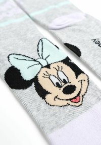 Calzini grigi con un vivace design di Minnie Mouse, caratterizzati da un fiocco verde menta, orecchie nere e dettagli del viso in nero, bianco e rosa.