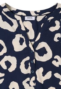 Navyblauwe blouse met crèmekleurige abstracte luipaardprint, V-hals, vijf knopen aan de voorkant en zachte, gladde textuurstof. Label: CECIL.