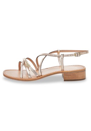 Sandale à brides avec une finition métallisée, bride de cheville ajustable, talon en bois plat et design ouvert à l'avant avec une semelle intérieure en cuir lisse.