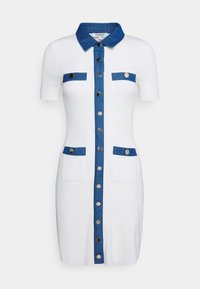 Robe blanche côtelée avec un devant boutonné en denim, des manches courtes, un col en denim et quatre poches avec des accents bleus et des boutons argentés.