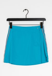 Turkos idrotts kjol med vita och marinblå sidostycken, knappstängning och liten logotyp nära fållen, hängande på en svart galge.