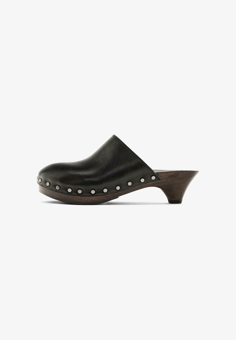 Sabot en cuir noir avec semelle en bois et talon bas effilé, décoré de clous argentés le long du bord de la semelle.