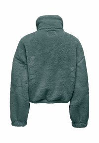 Veste polaire couleur sarcelle, dotée d'un col montant, d'une coupe courte et de poignets élastiqués. Surface douce et texturée avec une coupe carrée.