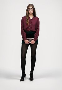 Maroon button-up blouse, green velvet mini skirt with dots, black tights, and high-heeled shoes. Accessories include a silver clutch.