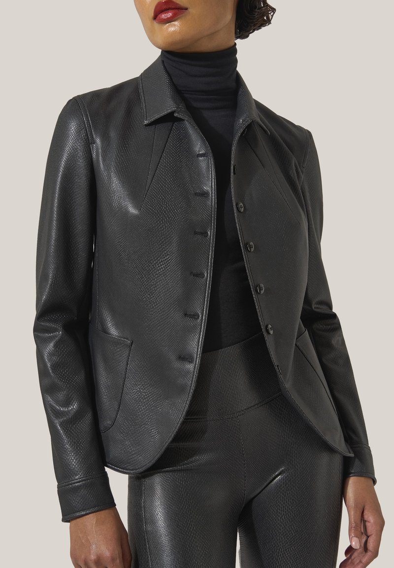 Svart läderjacka med texturerad ytfinish, skräddarsydd design, spetsig krage och knappstängning. Har framfickor och figurnära silhuett.