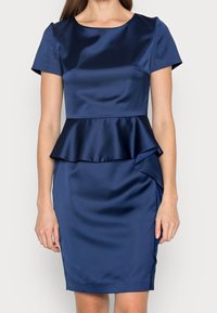 Marinblå satin klänning med peplummidja, korta ärmar och en figurnära siluett. Har en sidoflikdetalj och en mjuk textur.