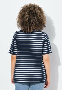 Camiseta a rayas azul marino y blanca con mangas cortas, de corte holgado y diseño de cuello redondo, hecha de una suave mezcla de algodón.
