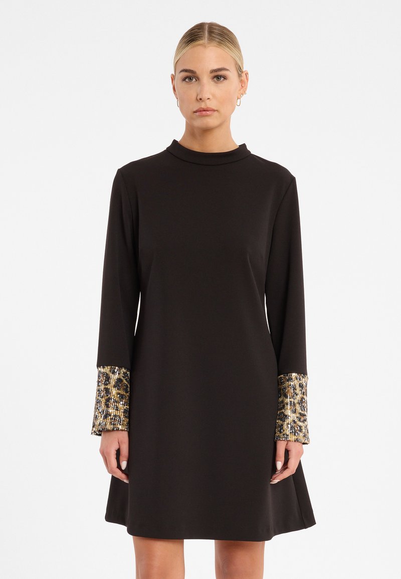 Schwarz langärmliges Kleid mit hohem Kragen, ausgestattet mit strukturierten goldenen und blauen gemusterten Manschetten und einem ausladenden Rock. Glattes Material.