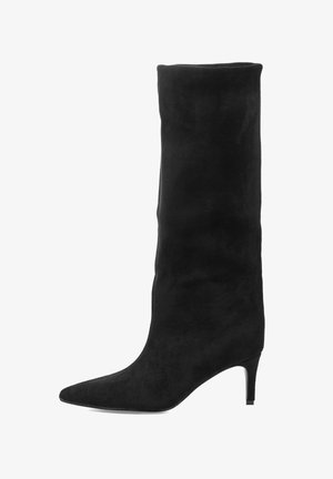 Bota negra de ante hasta la rodilla con punta puntiaguda y tacón delgado. El diseño presenta una textura suave y una silueta ceñida.