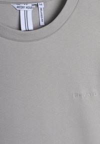 T-shirt in cotone grigio con vestibilità rilassata, collo rotondo e logo "MORATO" in rilievo sulla parte anteriore. Etichetta indicante la taglia Media.