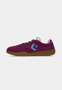 Purple textile sneaker with blue logo accents, black laces, and a gum rubber sole; features a padded collar for comfort.