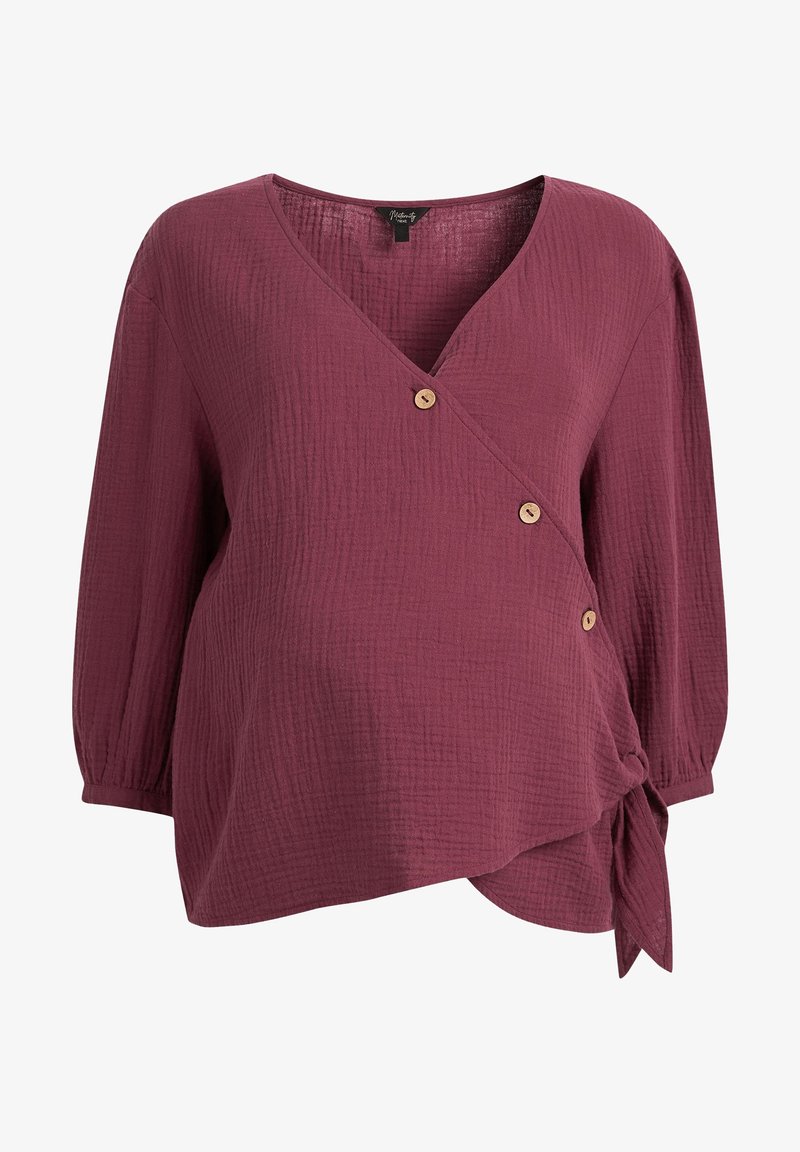 Haut portefeuille de maternité en bordeaux profond, en tissu texturé, avec un col en V, trois boutons en bois, et un détail à nouer sur le côté.